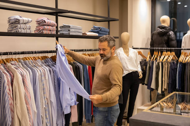 istock Mature man choosing clothes in a store 2148559790