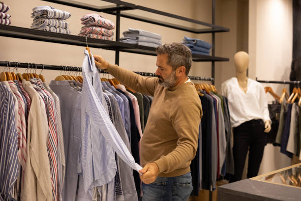 istock Mature man choosing clothes in a store 2148559796