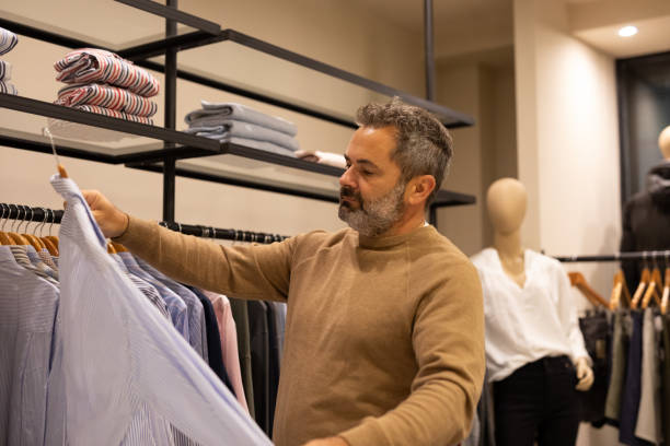 istock Mature man choosing clothes in a store 2148559808