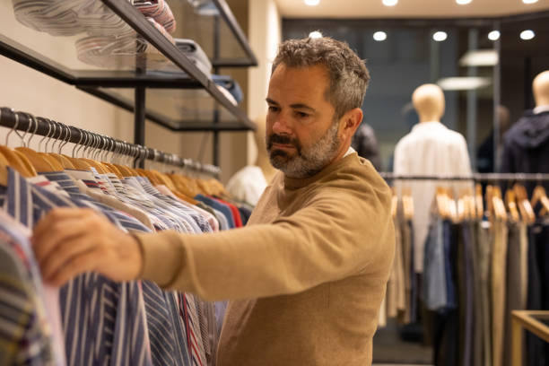 istock Mature man choosing clothes in a store 2148559825