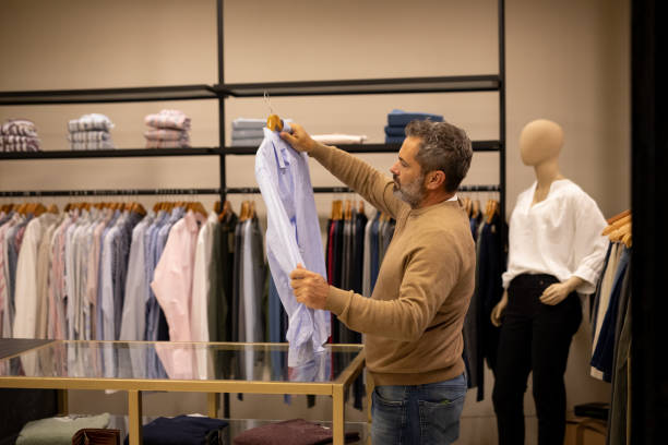 istock Mature man choosing clothes in a store 2148559838