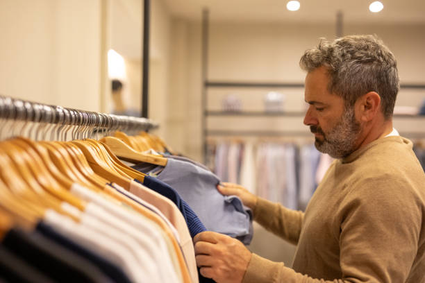 istock Mature man choosing clothes in a store 2148559840