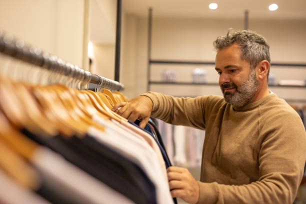 istock Mature man choosing clothes in a store 2148559843