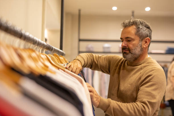 istock Mature man choosing clothes in a store 2148559849