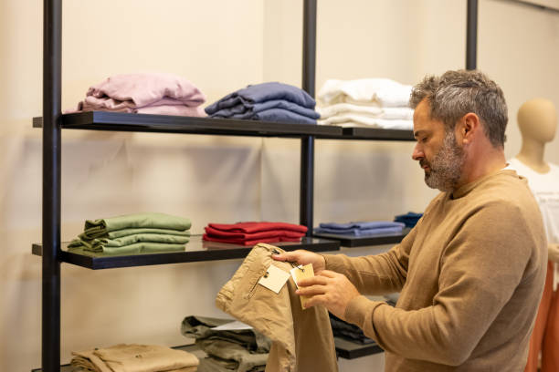 istock Mature man choosing clothes in a store 2148559854
