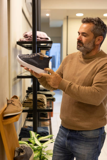 istock Mature man choosing clothes in a store 2148559875