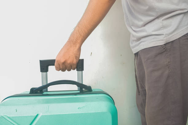 istock a man's hand holding a turquoise green suitcase 2148560294