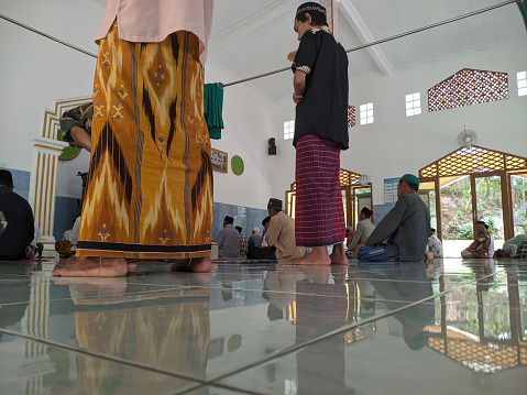 Cilacap, Indonesia - March 29, 2024 : Two Muslims are performing sunnah prayers before Friday prayers starting at noon time, in order to get rewards and blessings from their God