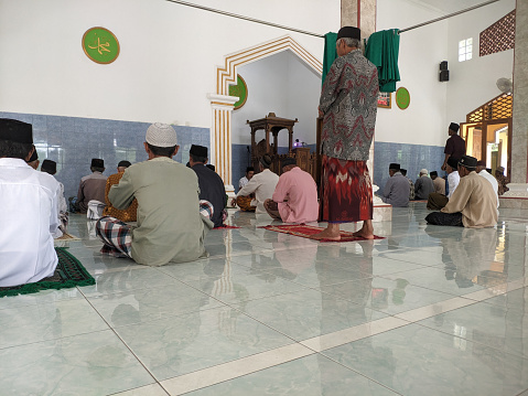 Cilacap, Indonesia - March 29, 2024: Muslim congregation sitting in a mosque preparing to attend Friday prayers in the month of fasting which is very blessed by their god