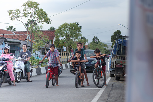 Cilacap, Indonesia - March 29, 2024 : several small children who were riding bicycles and stopped at the intersection waiting for the green light to turn on