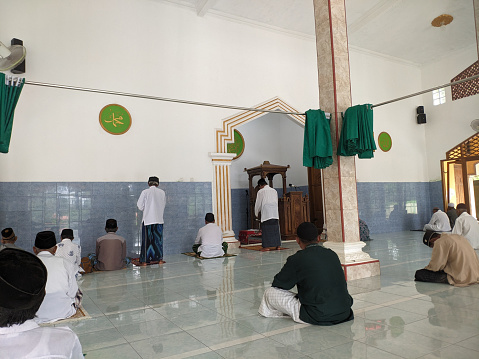 Cilacap, Indonesia - March 29, 2024: Muslim congregation sitting in a mosque preparing to attend Friday prayers in the month of fasting which is very blessed by their god