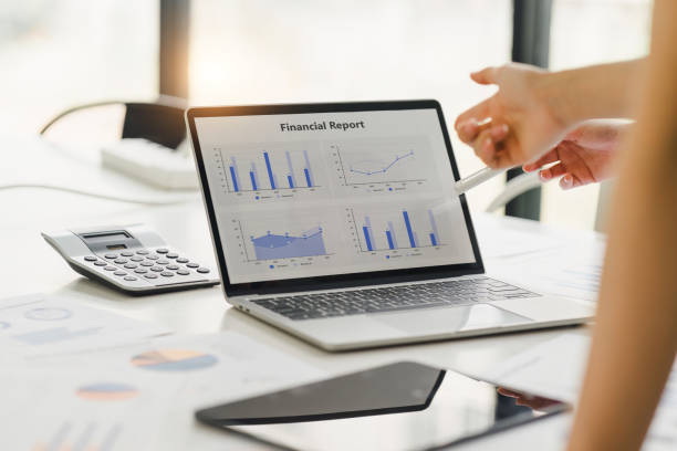 istock Two colleagues analyzing financial data reports on laptop with charts and graphs at modern office. 2148562872