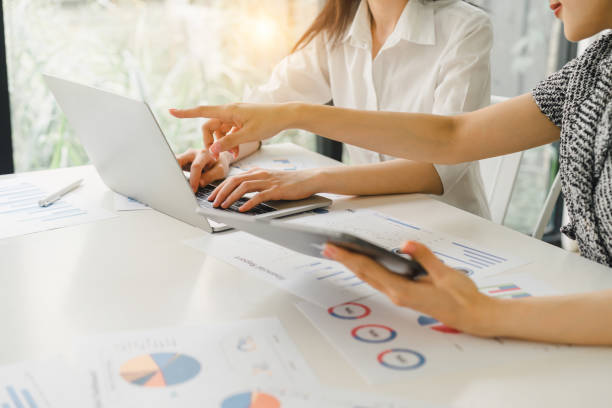 istock Business professionals engaged in financial analysis, using a calculator and discussing data on a laptop and various charts. Colleagues Collaborating with Laptop on Business Analytics. 2148563144