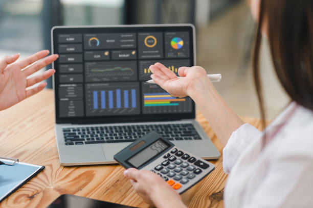 istock Two colleagues engaged in business analytics, using digital tablets over financial charts. Colleagues Collaborating with Tablets on Business Analytics. 2148563213
