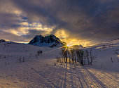 Senja's sunset over snowy mountains in winter