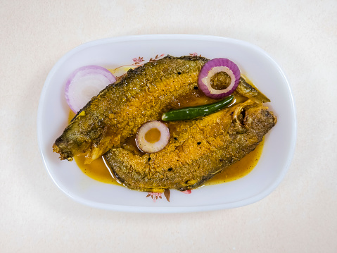 Indian spicy Parshe fish cusine, garnished with onion and green chilli which is served as a side dish with rice.