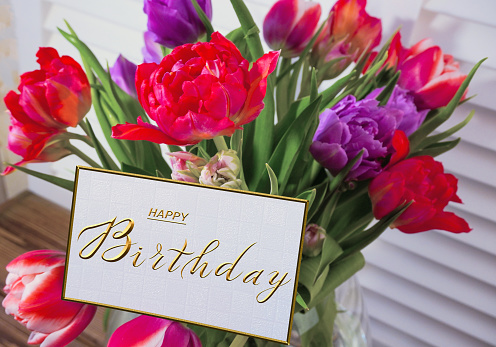 postcard , Internet banner  with a birthday greeting, with the inscription - happy birthday, a bouquet of flowers with a note of congratulations,  tulips