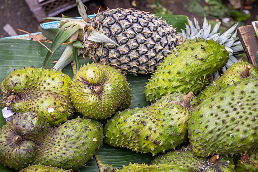 Soursops and pineapples for sale at a market stall at the famous food market in Berastagi in North Sumatra