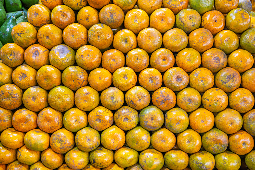 Pile of ripe oranges at a market stall at the famous food market in Berastagi in North Sumatra