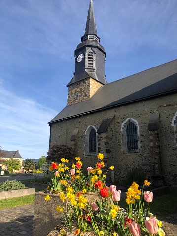 L’église dans la ville de Changé, avec des fleurs colorées, en Sarthe, en France