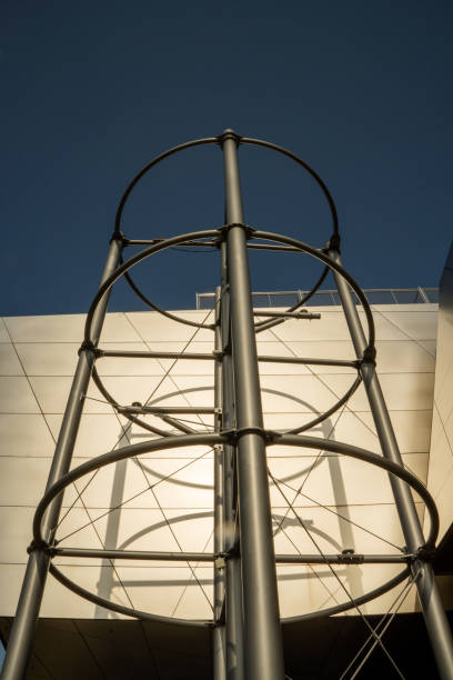 istock Round metal structure on modern building facing up against deep blue sky. Modern architecture 2148570793