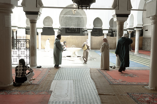 03/28/2015 - Fest, Morocco: Worshippers and visitors engage in quiet reflection in the tranquil courtyard of a Fes mosque