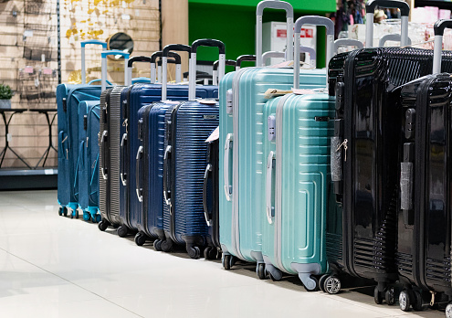A customer chooses a suitcase for luggage in a department store. Buying small luggage for a business trip. Tourism.