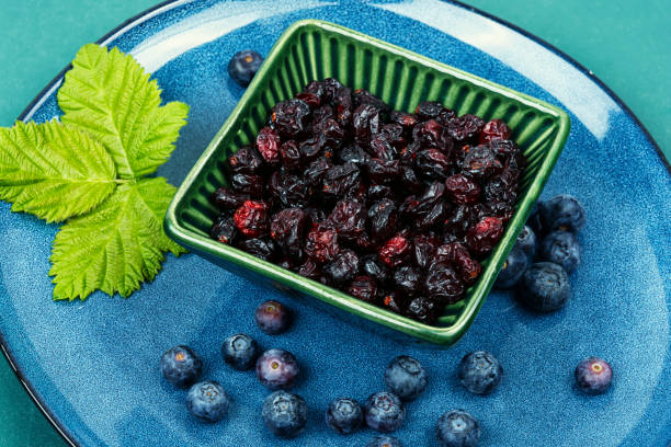 Bowl with tasty dried cranberries and blueberries. Raw blueberries and dried cranberries.