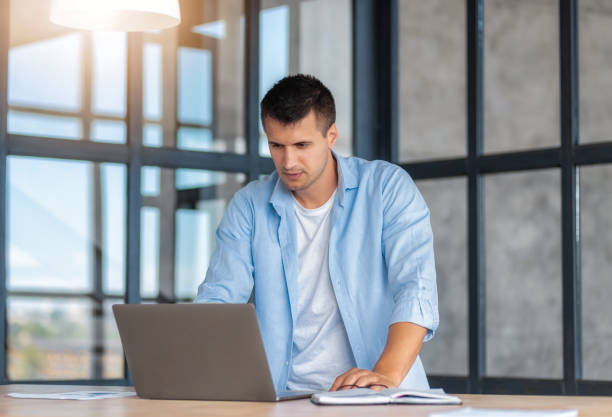 istock Successful Business man Entrepreneur standing near workplace working using laptop in modern office 2148576478