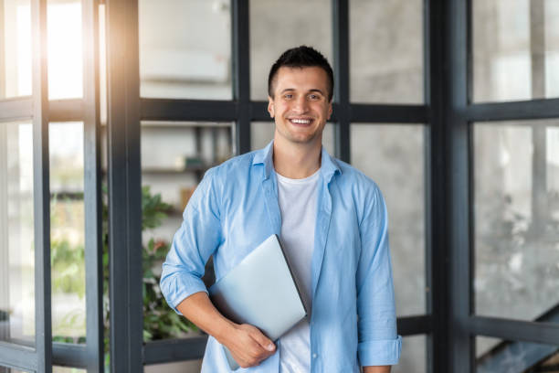 istock successful man entrepreneur stands with laptop in modern office 2148576789