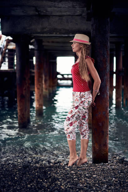 istock Young woman standing under the rusty pier 2148577384
