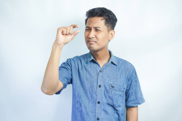 istock Young Asian man showing invisible abstract small subject or object. Tiny concept. 2148577571