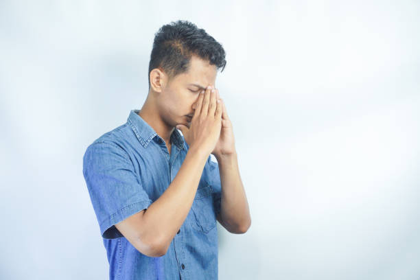 istock Pray, faith and mockup with a man in studio on a white background asking god for a miracle or help. Trust, religion and spiritual with a handsome young male praying to in belief 2148577782