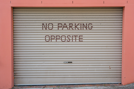 No parking sign on a metal garage door.