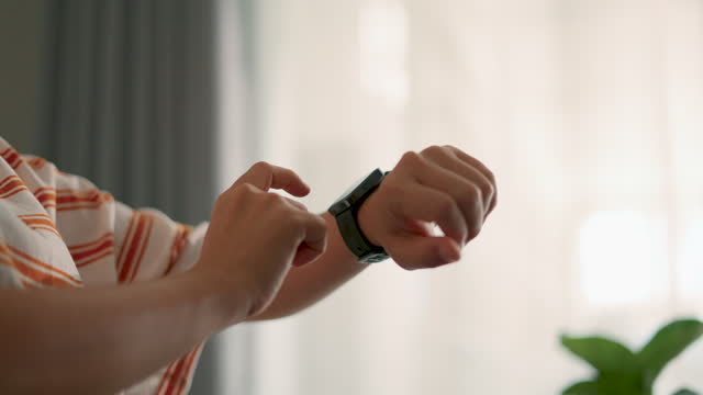 Close-up shot of woman touching on smartwatch, using smart watch application for checking time or taking pulse.