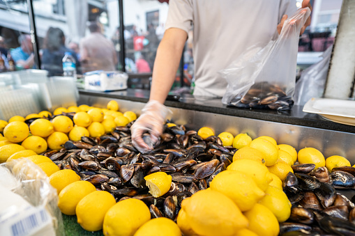 stuffed mussels are on showcase man hand is selling horizontal small business retail still
