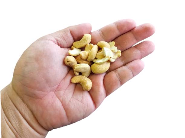 istock Cashew nuts on people's hand. Isolated on white background. 2148581992