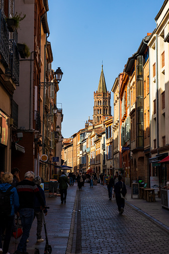 Octagonal bell tower in red bricks of the Basilica of Saint-Sernin in Toulouse seen from Rue du Taur
