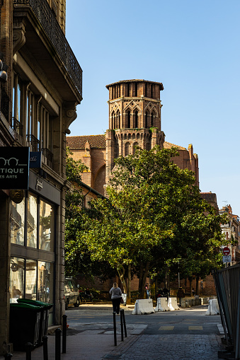 Perspective on the bell tower in red bricks of the Church of the Augustins from Rue des Arts in the center of Toulouse