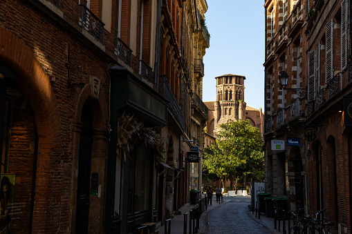 Perspective on the bell tower in red bricks of the Church of the Augustins from Rue des Arts in the center of Toulouse
