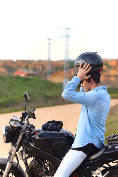 istock Young Caucasian man sitting on his motorcycle putting on his helmet 2148582434