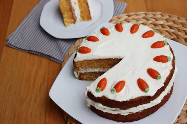 istock Sliced  carrot cake with cream cheese icing and mini marzipan carrot 2148583152