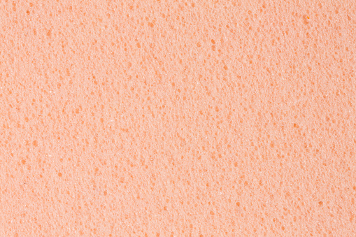 Simple gently light orange, creamy, pink ethylene vinyl acetate foam, foamiran texture. High resolution photo.
