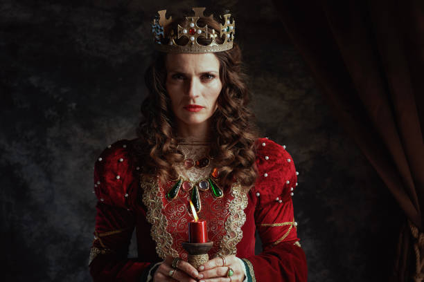 istock medieval queen in red dress with candle and crown 2148584397