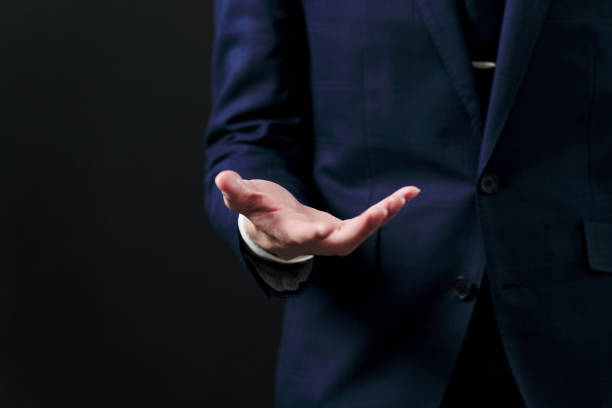 istock Businessman holding out his hand on black background 2148584721
