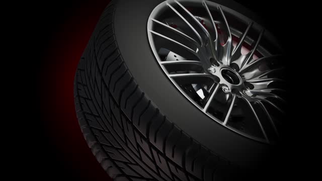 Close-Up Video of a Rotating Shiny Car Wheel and Tread Detail on a Dark Background