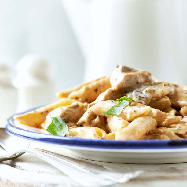 istock Penne Pasta baked with Meat on bright wooden Background. 2148588565