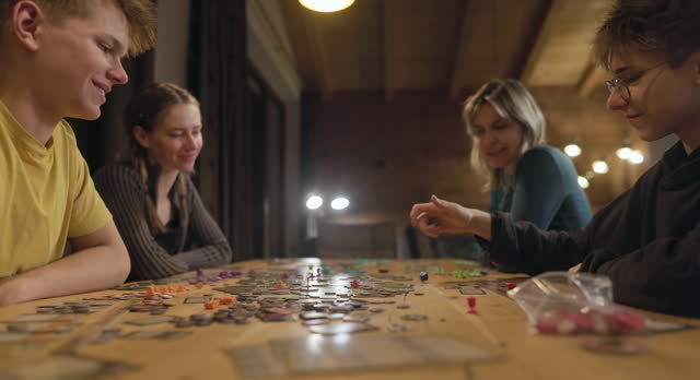 Family playing large modern board game together at home