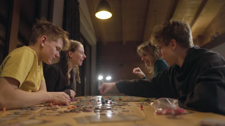 Family playing large modern board game together at home