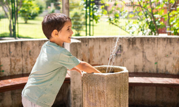 istock child playing at fountain in a public park 2148589103